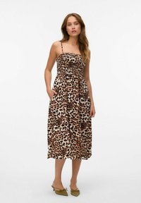Haljina s leopard uzorkom s tankim naramenicama, prilagođenim tijelom i bočnim džepovima. Čini se da je materijal lagan s labavim, lepršavim oblikom.