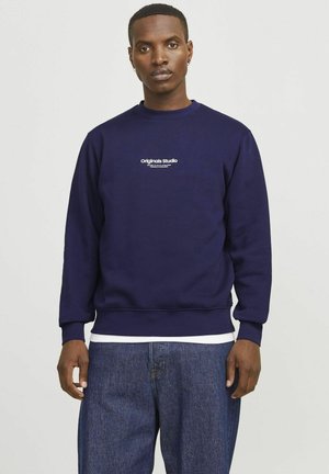 Marinefarbener Sweatshirt mit Rundhalsausschnitt und Rippbündchen. Mit einem weißen "Originals Studio"-Grafikdesign auf der Brust. Der Stoff besteht aus glattem Baumwollmaterial.