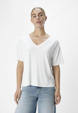 T-shirt blanc à col en V avec des manches courtes, fabriqué en tissu doux, associé à un jean évasé bleu clair. Design épuré et minimal.