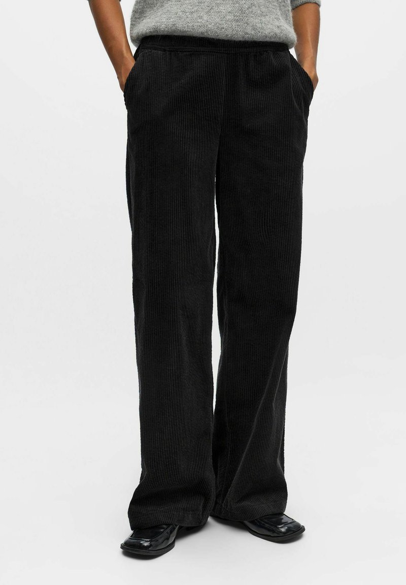 Pantaloni neri in corduroy a gamba larga con un motivo a righe testurizzato, dotati di tasche laterali e una vestibilità rilassata. Adatti per un abbigliamento casual.