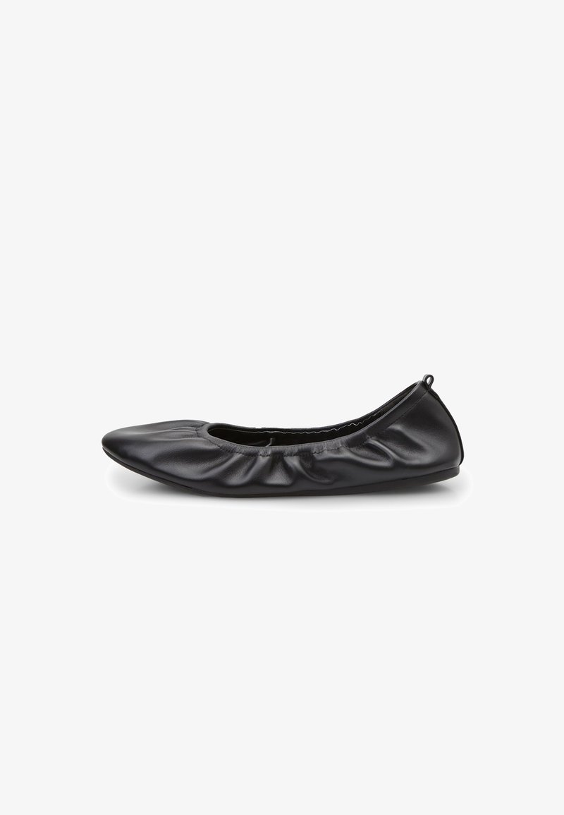 Zapato plano tipo ballet de cuero negro con punta puntiaguda, textura fruncida a lo largo de los lados y suela suave y flexible. Sin herrajes ni adornos visibles.