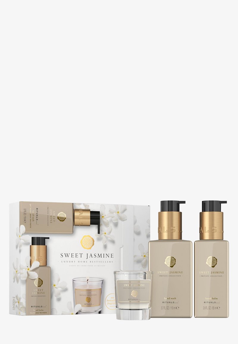 Coffret cadeau maison de luxe Sweet Jasmine avec deux flacons pompe beiges, accents dorés et une bougie transparente. Motif floral sur l'emballage.