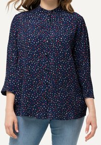 Navy blue button-up blouse with a high neckline, three-quarter sleeves, and a scattered floral pattern in red and beige hues.