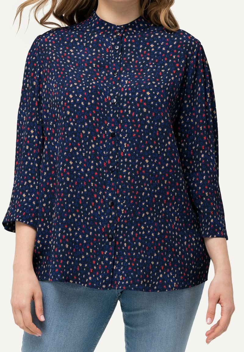 Navy blue button-up blouse with a high neckline, three-quarter sleeves, and a scattered floral pattern in red and beige hues.