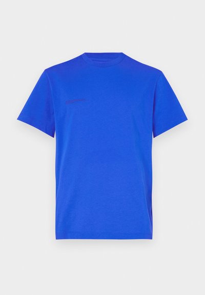 Camiseta de algodão azul com colarinho redondo e mangas curtas; apresenta um pequeno detalhe em texto no lado superior esquerdo.