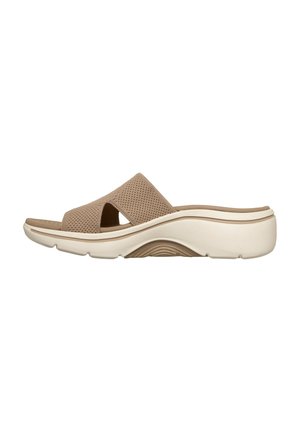 Beige instapsandaal met bovenwerk van mesh, open teen en dikke witte gevormde zool, ontworpen voor comfort en casual gebruik.