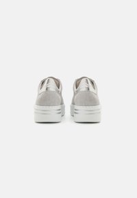 Baskets à texture argentée avec une finition en suède, dotées de semelles blanches épaisses et d'accents métalliques au talon. Conception pour usage intérieur.