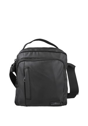Bolso de hombro de tela negra con asa superior, correa ajustable, compartimento principal con cremallera, bolsillo frontal y detalles de superficie texturizada.