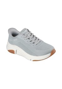 Zapatilla gris claro con parte superior de malla, punta redondeada y cordones. Media suela blanca con suela de goma marrón. Presenta un sutil patrón texturizado.