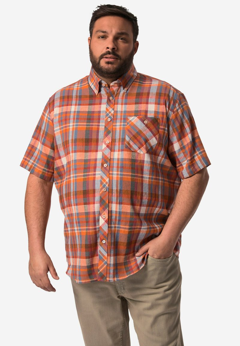 Košile krátkého rukávu s kostkovaným vzorem v oranžové, modré a b�éžové barvě. Obsahuje límec na knoflíky a náprsní kapsu. Nosené s kalhotami světlé barvy.