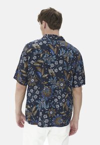 Cămașă cu mânecă scurtă dintr-un material bleumarin închis, cu un model floral în nuanțe de albastru, maroniu și alb. Croială lejeră, cu guler și tiv curved.