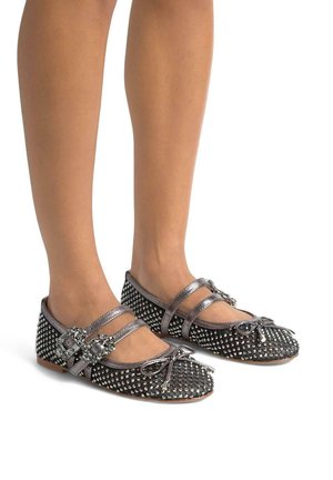 Bailarinas negras con acentos metálicos, parte superior tachonada, dos tiras cruzadas y detalle de lazo en la punta. Textura lisa y suela plana.