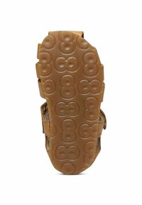 Brun gummisula med cirkulära mönster och strukturerat grepp, med en design med två remmar och förstärkt hälstöd.