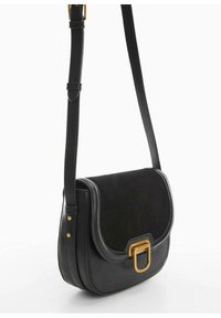 Sort læder crossover taske med ruskindselementer, afrundet form, justerbar rem og detaljer i guldmetal på lukningen.