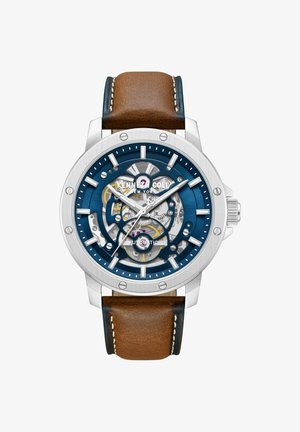 Automatski ručni sat Kenneth Cole sa srebrnim kućištem, izloženim zupčanicima, plavim brojčanikom, bijelim oznakama i smeđim kožnim remenom sa šavovima.