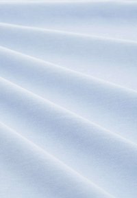 Ljusblått, texturerat tyg med en slät yta, som har distinkta diagonala veck och ett konsekvent vävmönster.