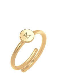 Anello d'oro con cima circolare featuring una lettera "K" incisa. Banda di metallo liscia con design a spacco, contrassegnata "925" per la purezza dell'argento.