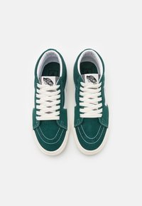 Grüne Wildleder-Sneaker mit weißen Schnürsenkeln, Gummisohlen und tonal abgesteppten Nähten. Verfügt über einen weißen Seitenstreifen und einen gepolsterten Kragen für zusätzlichen Komfort.