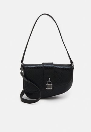Sac à bandoulière noir en cuir synthétique avec surface texturée, rabat arrondi, fermeture décorative argentée et sangle réglable sur fond uni.