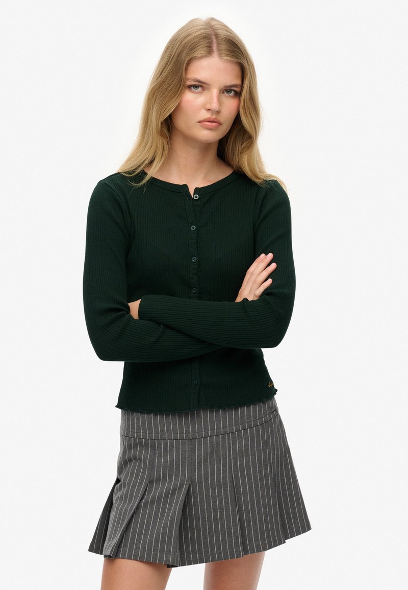 Ciemnozielony kardigan z prążkowanej dzianiny, z długimi rękawami i okrągłym dekoltem, z zapięciem na guziki i lekko skróconym dołem.