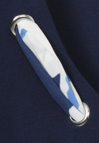 Marine stoffen met een ronde zilveren oog en een stoffen handvat in het wit met blauwe patronen, met een gestructureerde oppervlakte en een zachte afwerking.