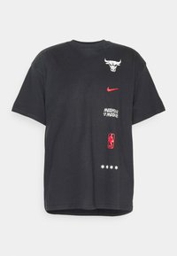 Camiseta de algodón negra con un gráfico de un toro, logo de Nike en rojo, texto y logo de la NBA. Los acentos incluyen cinco estrellas blancas cerca del dobladillo.