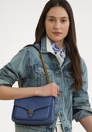 Sac à main en cuir bleu avec une anse en chaîne dorée, doté d'une fermeture à rabat et de détails cousus. Le design est rectangulaire avec une forme structurée.