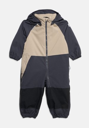 Ολόσωμη φόρμα με κουκούλα για παιδιά, με μπροστινό φερμουάρ, ελαστικά μανίκια και σχέδιο με μπλοκ χρωμάτων σε μπεζ, σκούρο γκρι και μαύρο.