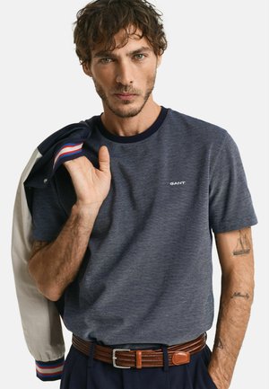Navy blue short-sleeve t-shirt with a textured finish and a round neckline, featuring a small white logo and contrasting collar detail.