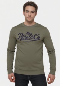Sudadera verde oliva con mangas largas, puños y dobladillo acanalados. Presenta un texto de logo en azul oscuro "Petrol & Co" en el pecho.
