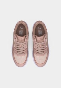 Ζευγάρι ροζ παπούτσια Puma με λευκές σόλες και σχεδιασμένα μπροστινά τμήματα, φαίνονται από πάνω σε λευκό φόντο.