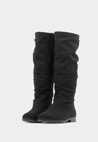 Bottes noires montant jusqu'au genou, en tissu doux et extensible avec une texture lisse. Dotées d'une fermeture éclair latérale et d'un talon bas et empilé.