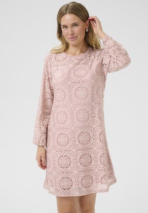 Abito in pizzo di un delicato rosa con un motivo a quadrati, maniche lunghe, scollatura tonda e tessuto strutturato con dettagli intricati.