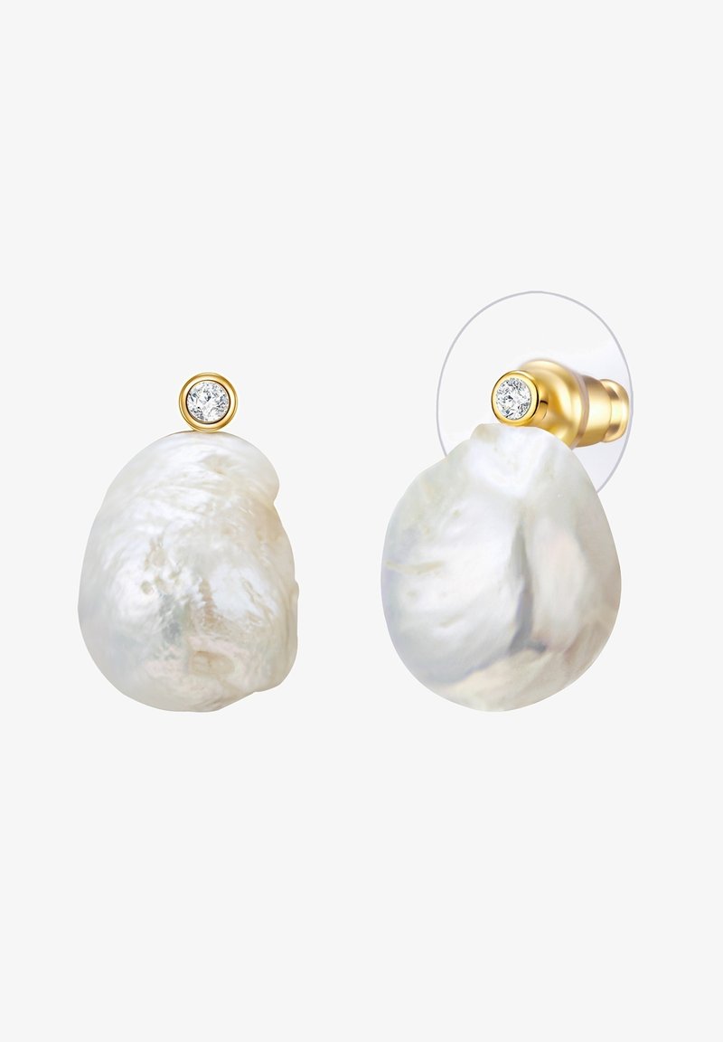 Pärlitega stud-kõrvarõngad ebatavaliste kujunditega, selge kivi aksessuaari ja kuldse raami peal. Tekstureeritud valge pind, millel on looduslikud variatsioonid.