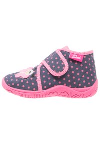 Child's shoes with a navy polka dot fabric, pink accents, Velcro strap, and a pink rubber sole featuring a playful design.