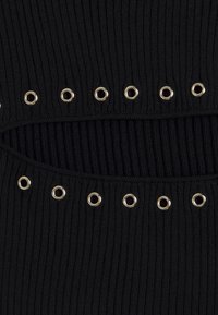 Tissu noir côtelé avec deux rangées horizontales d'œillets en métal argenté espacés uniformément, créant un motif texturé et un détail ajouré.