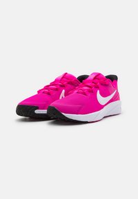 Baskets de sport roses vives avec un dessus texturé, un logo blanc, des lacets plats et un contrefort de talon noir. Présente une semelle extérieure noire durable.