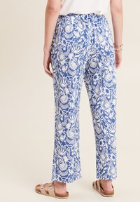 Blauw-witte broek met een bloemenpatroon, met een relaxed fit en een elastische tailleband. Draagt u met platte sandalen.