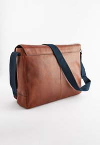 Geantă tip messenger maro din piele, cu suprafață texturată, curea bleumarin, formă dreptunghiulară și închidere cu fermoar pe marginea superioară.