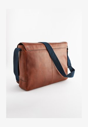 Braune Leder-Umhängetasche mit strukturierter Oberfläche, marineblauem Riemen, rechteckiger Form und einem Reißverschluss entlang der Oberkante.