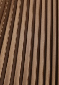 Tejido plisado de un rico color marrón, con una textura suave y pliegues verticales uniformes, que transmiten una sensación de profundidad y dimensión.