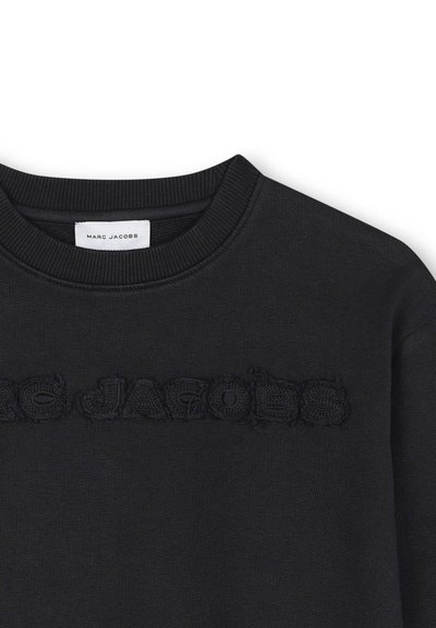 Felpa nera con scollo a coste e logo testurizzato. Tessuto morbido con cuciture sottili, che mettono in risalto il nome del marchio in filo.