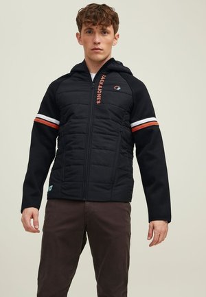 Black jacket with a zip front, padded torso, and hood. Features colored stripes on the sleeves and a logo embroidered on the chest.
