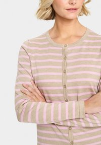 Beige cardigan med ljusrosa ränder, rund halsringning och stängning med sex knappar. Mjuk textur och lång ärm.