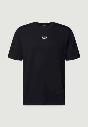 Maglietta nera in cotone con un piccolo emblema bianco a forma di scudo sul petto, con scollo classico a girocollo e maniche corte.