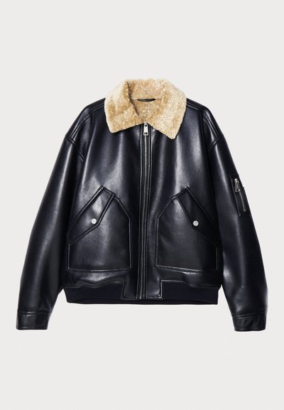 Veste en cuir noir avec col en fourrure, dotée de deux poches à l'avant, d'une poche zippée sur la manche et de bords côtelés au bas et aux manches.