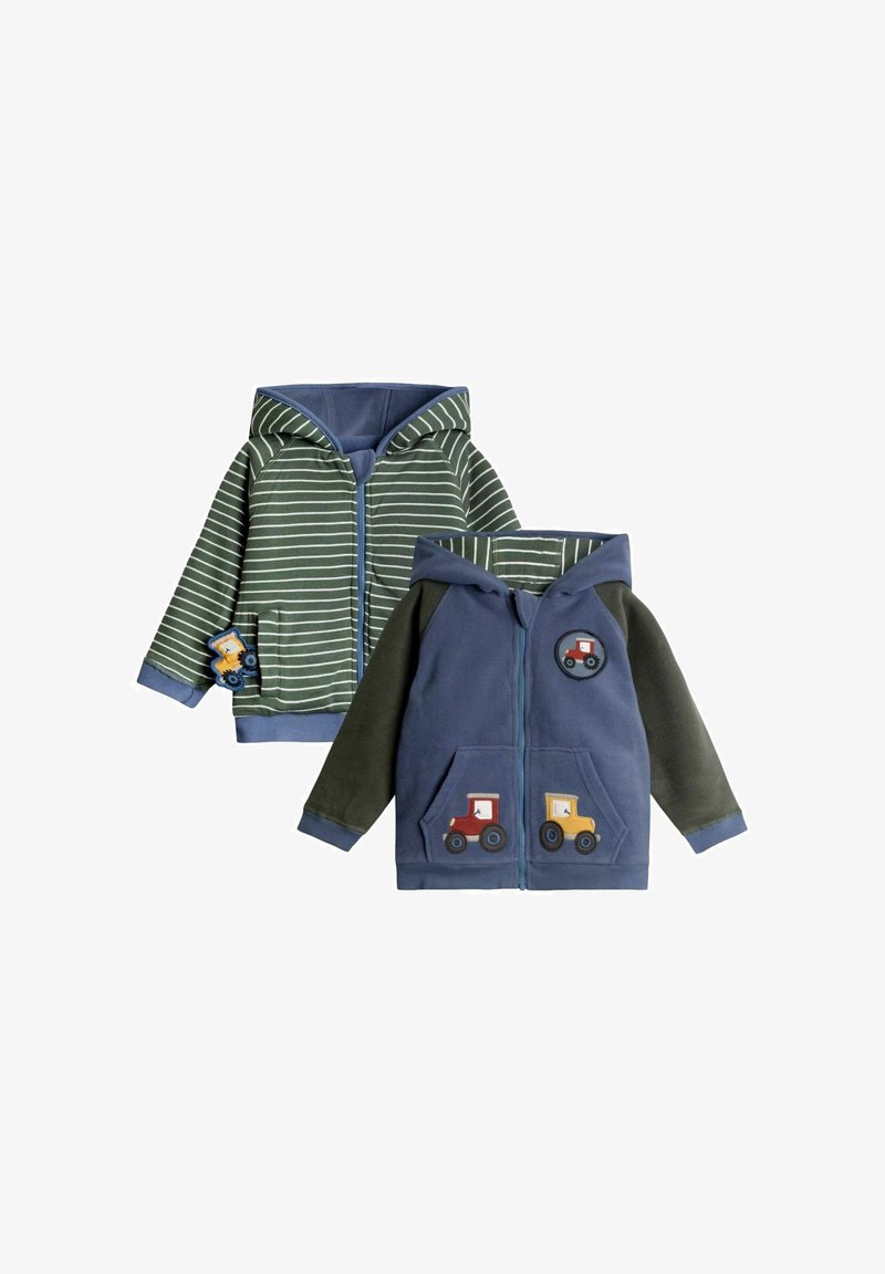 Kaputšaga tõmblukuga jope, millel on roheline triibuline muster ja sinised aktsendid. Ühel küljel on veoautode aplikaadid, samas kui teine külg on solidne sinine.