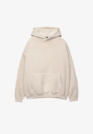 Beige Kapuzenpullover aus weichem Baumwollstoff. Verfügt über eine Kängurutasche und gerippte Bündchen, mit einem kleinen Logo auf der Brust gestickt.