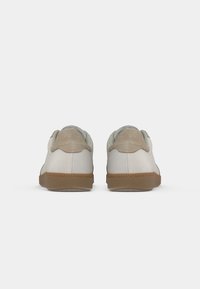 Sneakers met een lichtbeige bovenwerk van gladde stof, verfraaid met een getextureerde lichtbruine hak en een bruine rubberen buitenzool.