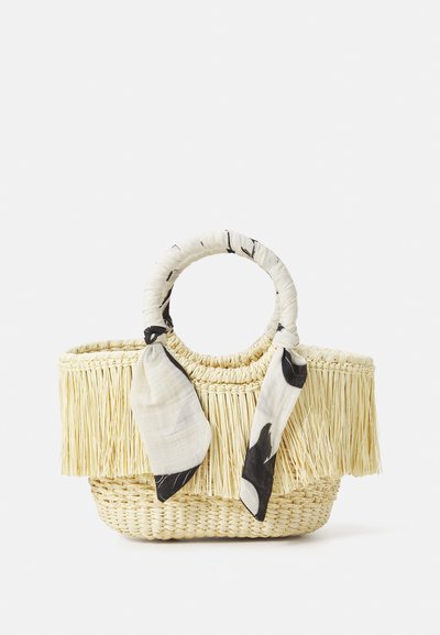 Woven straw handbag with round handle, decorated with black and white patterned scarf, featuring fringed top and natural beige color.